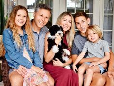 a family sitting on a couch holding a dog