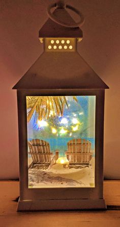 a lit up lantern sitting on top of a wooden table next to a palm tree