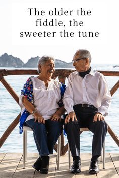 an older couple sitting on a bench next to the ocean with text overlay that reads, the older the fiddle, the sweeter the tune