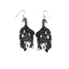 pair of black and white earrings with an animal design on the front, side and back