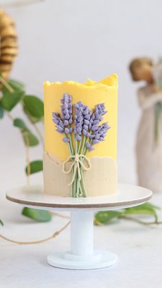 a yellow and white cake with lavenders on it