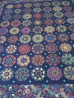 a blue quilt with many circular designs on it