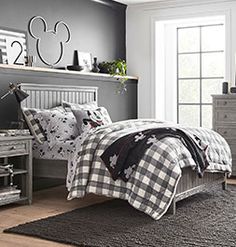 a bedroom with mickey mouse bedding in black and white