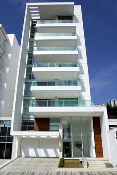 a tall white building with balconies and windows