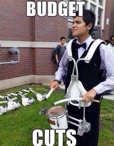 a man in an apron is playing drums outside