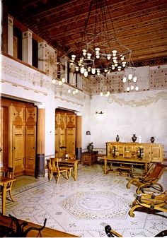 an ornately decorated room with wooden furniture and chandelier hanging from the ceiling