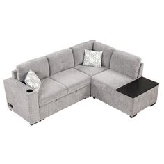 a gray sectional sofa with two pillows and a coffee table on the bottom right side