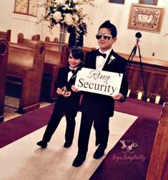 two boys in tuxedos holding up a sign that says king security