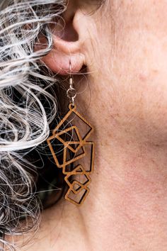 a close up of a person wearing some kind of wooden earring on their ear