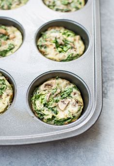 several muffins with spinach and mushrooms in a metal pan on a counter