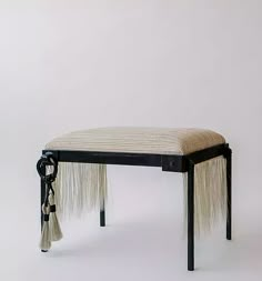 a small bench with fringes on it