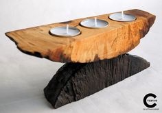 three tealight candles are placed on top of a piece of wood that looks like a log