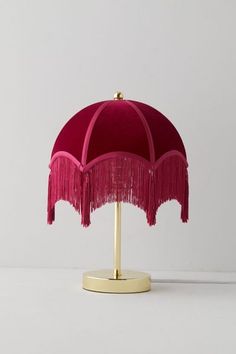 a pink lamp with fringes on it