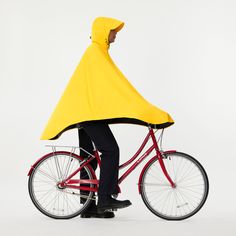 a man in a yellow raincoat is riding a red bike with his back turned to the camera