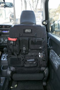 the back seat of a vehicle with various items in its pocket and on it's side