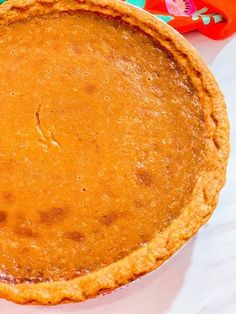 a pumpkin pie sitting on top of a white table