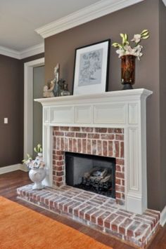 a living room with a fireplace and pictures on the wall above it's mantle