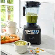 a blender sitting on top of a counter filled with green liquid