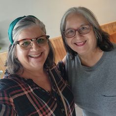 two women standing next to each other smiling