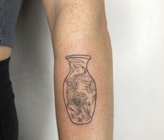 a tattoo on the arm of a woman with a vase in it's center