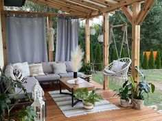 an outdoor living area with hanging chairs, couches and potted plants on the deck