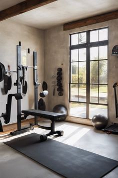 Home gym with weightlifting equipment and large window. Garage Gym Playroom, Gym Corner In Garage, Aesthetic Garage Gym, Home Gym Posters, Small Home Gym Decor, Gym Room Aesthetic, Cool Home Gym, Small Gym At Home, Modern Gym Interior Design