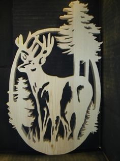 a wooden cutout of a deer with trees in the background