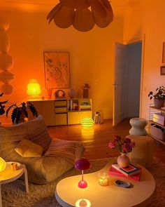 a living room filled with furniture and lots of orange lighting on the walls above it