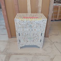 a white wooden cabinet sitting on top of a floor