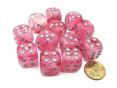 pink dices with silver dots are next to a penny