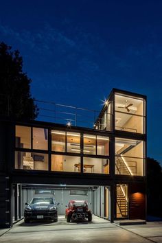 two cars are parked in front of a large modern house with glass walls and stairs