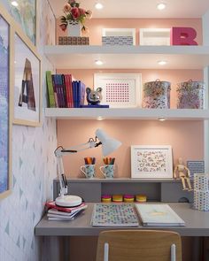 a desk with some books on top of it and pictures above the desk in front of them