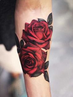 a close up of a person's leg with red roses on the thigh and arm