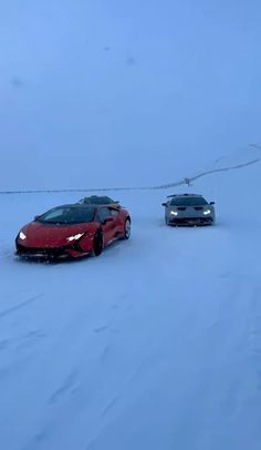 two cars driving in the snow near each other