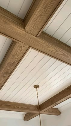 a ceiling with wooden beams and a chandelier hanging from it's side