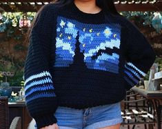 a woman is smiling while wearing a sweater with the image of the starr wars on it