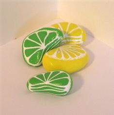 three lemons and two lime slices are sitting on a white counter top next to each other