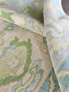 an upholstered fabric with blue and green flowers on the outside, as well as a white shoe