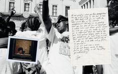 a group of people standing next to each other in front of a building with writing on it