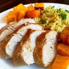 a white plate topped with meat, rice and veggies next to carrots