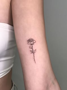 a single rose tattoo on the left arm