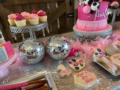 a table topped with lots of cakes and cupcakes