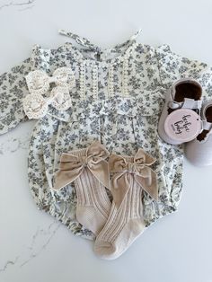 This long sleeve baby romper features a high neck and ruffled trim, perfect for keeping your little one stylish and comfortable. Made from soft cotton material, this romper also sports a beautiful floral print, adding a touch of charm and sophistication to any outfit. Cute Long Sleeve Jumpsuits And Rompers For Fall, Cute Long Sleeve Jumpsuits For Fall, Long Sleeve Cream Onesie For Spring, Cream Long Sleeve Onesie For Spring, Cream Long Sleeve Onesie For Fall, Spring Long Sleeve Ruffled Onesie, Fall Cream Cotton Onesie, Cream Long Sleeve Cotton Jumpsuit, Cute White Jumpsuits And Rompers For Fall