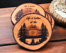 three wooden coasters with trees and the words life is better at the lake