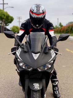 a man riding on the back of a motorcycle down a street