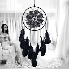 a woman sitting in a chair next to a dream catcher