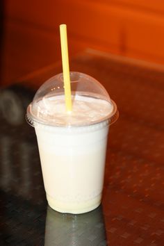 a plastic cup with a yellow straw in it