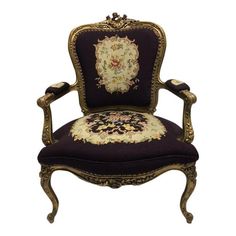 an ornately decorated chair with purple upholstered seat and gold trimmings