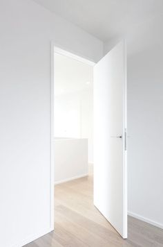 an empty room with white walls and wooden floors