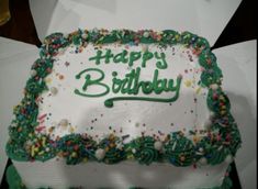 a birthday cake with green frosting and sprinkles